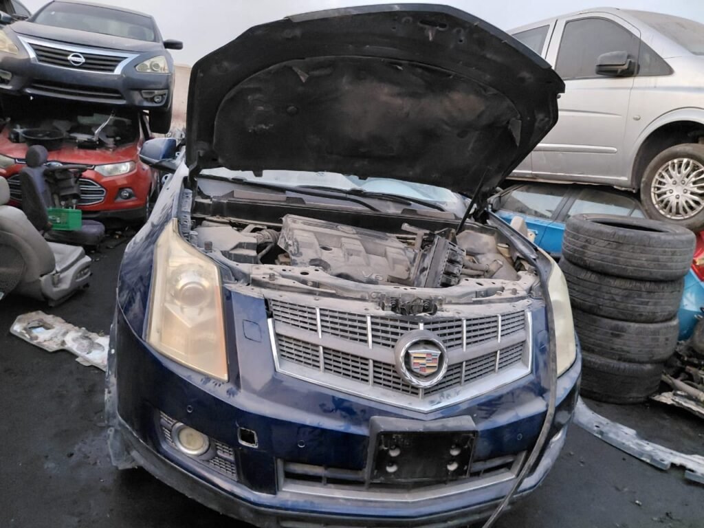 Red Hyundai Sonata scrap vehicle among engines and parts in Abu Dhabi